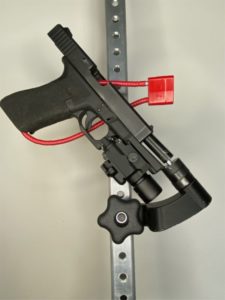 Close up of Gunhanger with a gun locked in by a red gun lock.